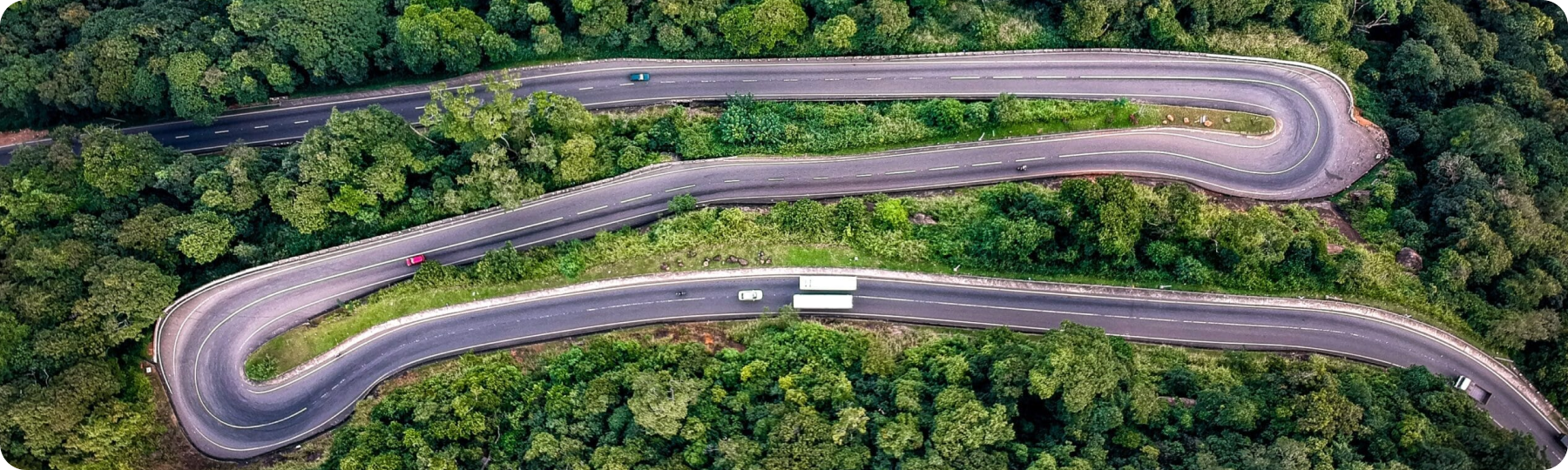 Aerial view of semi-trucks navigating a winding mountain road